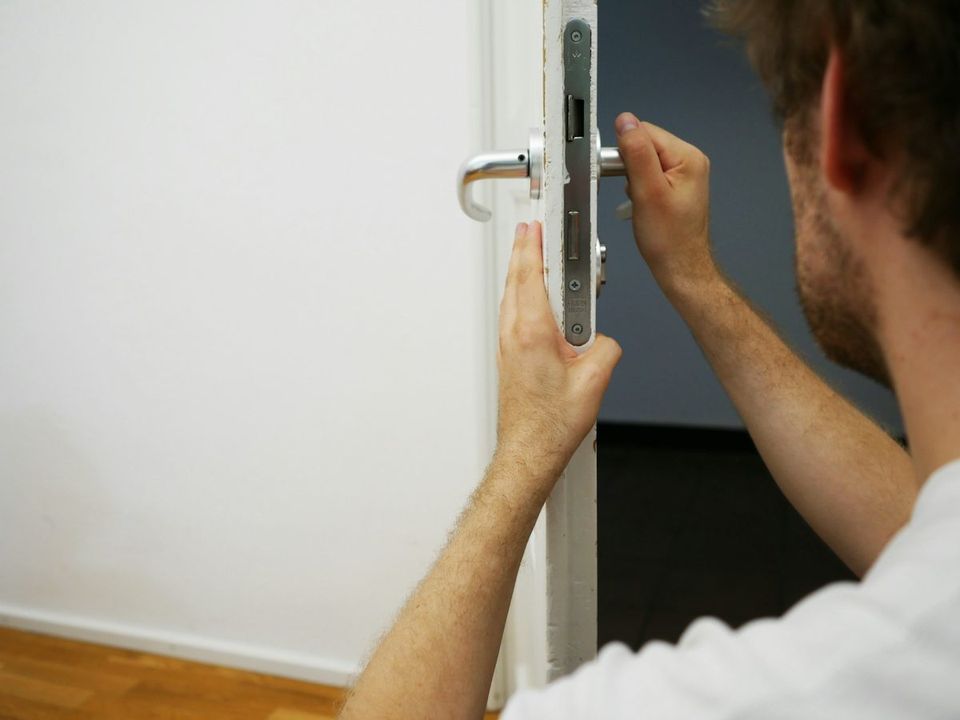 Technician installing a door lock on an interior door