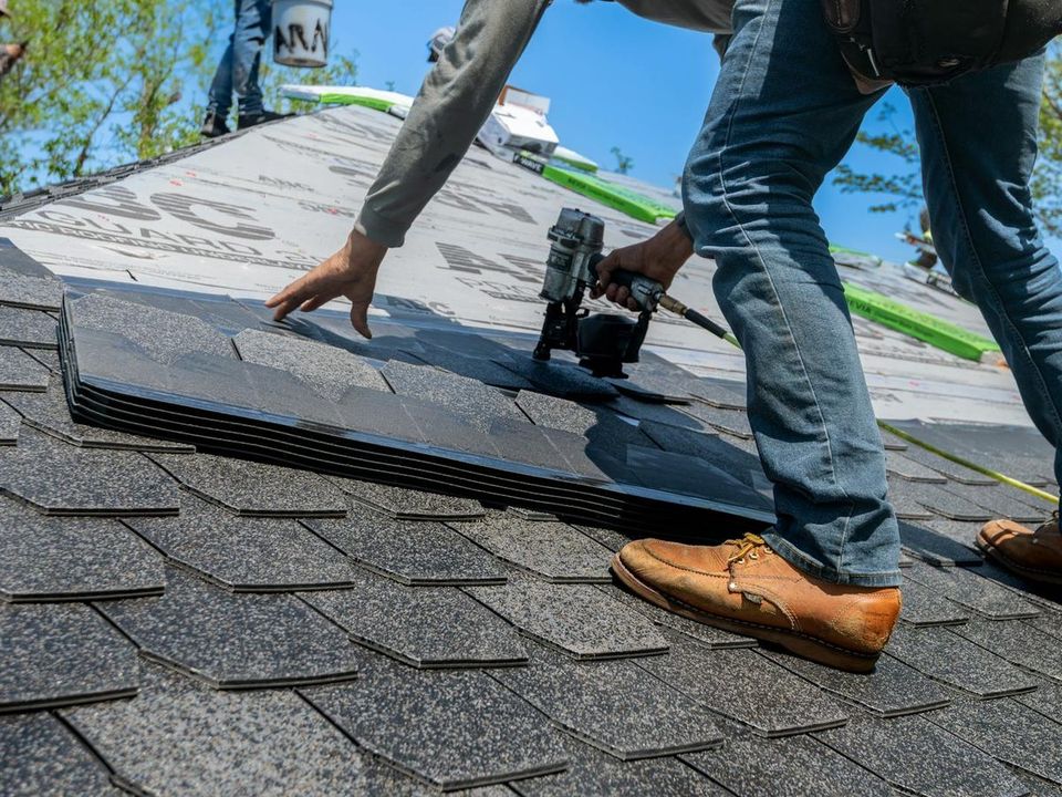 Professional roofer installing shingles on a residential roof