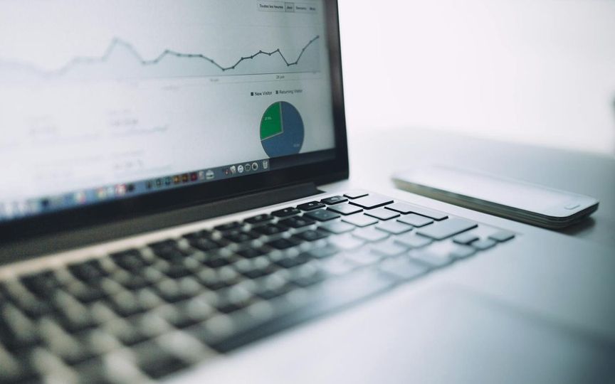 Laptop displaying analytics dashboard with charts and graphs